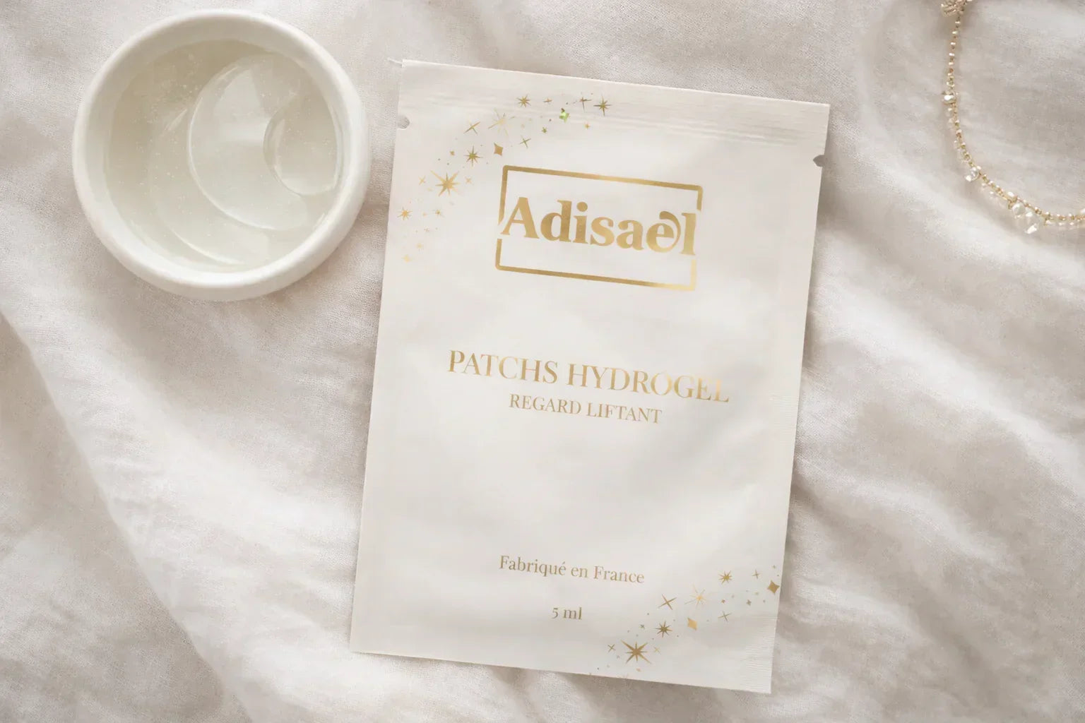 Patchs hydrogel pour les yeux, liftant, posés sur un tissu blanc, ambiance spa relaxante.